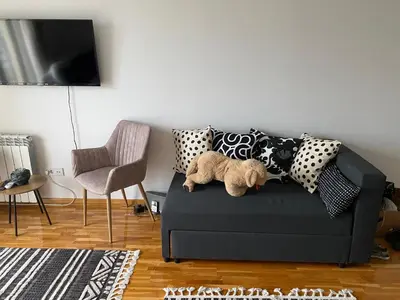 a teddy bear sitting on a couch in a living room at Green Residence in Belgrade