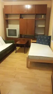 a room with two beds and a table and a microwave at Nina Lili in Mirijevo