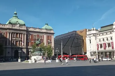 a group of people walking around a city square at Authentic Belgrade Centre - 3 Suites in One Space, with patios in courtyard for smokers in Belgrade