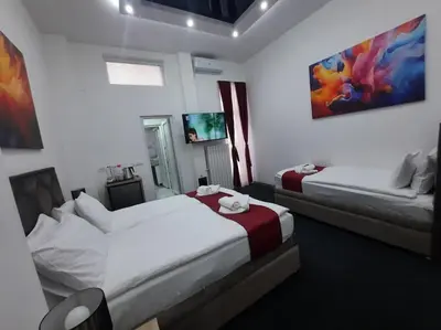 two beds in a hotel room with two beds at Authentic Belgrade Centre - 3 Suites in One Space, with patios in courtyard for smokers in Belgrade