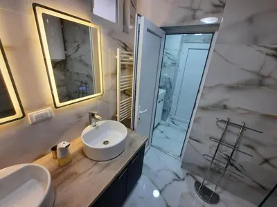 a bathroom with a sink and a glass shower at Authentic Belgrade Centre - 3 Suites in One Space, with patios in courtyard for smokers in Belgrade