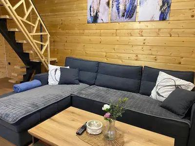 a living room with a blue couch and a table at Luxury house Nena Fruška gora - kuća za odmor in Velika Remeta