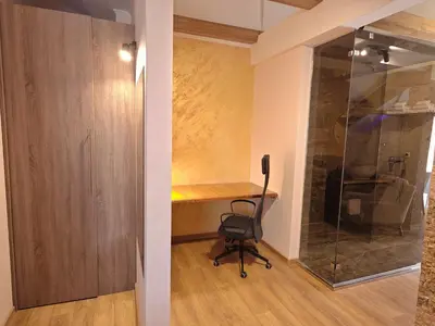 a room with a desk and a chair next to a glass wall at Green Land Club in Novi Banovci