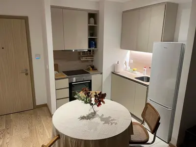a kitchen with a table with a vase of flowers on it at Aurora 011 in Sajmište