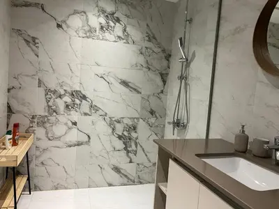 a bathroom with a sink and a marble wall at Aurora 011 in Sajmište