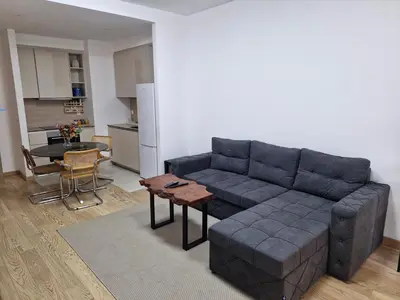 a living room with a blue couch and a table at Aurora 011 in Sajmište
