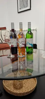 two glasses and two bottles of wine on a glass table at Apartman Resavska in Belgrade