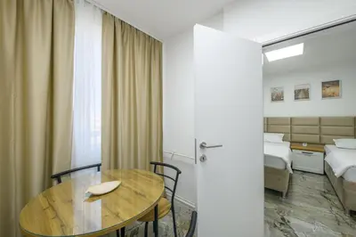 a hotel room with a table and a bed at NAŠ Apartman in Voždovac