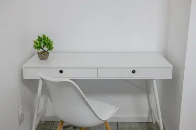 a white desk with a potted plant on it at NAŠ Apartman in Voždovac