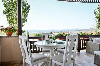 a white table and chairs on a balcony with a view at Glamping Home in Bukovik