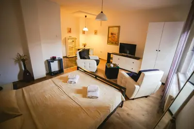 a living room with a bed and two chairs at Lina Apartments in Belgrade