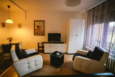 a living room with two white couches and a table at Lina Apartments in Belgrade