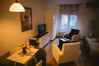 a living room with a couch and a table and a tv at Lina Apartments in Belgrade
