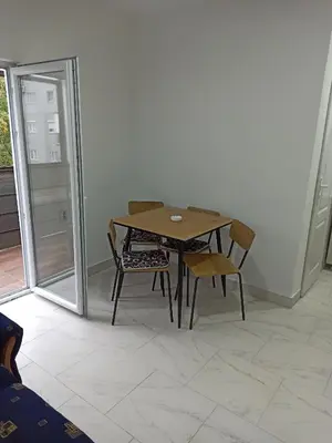 a wooden table and chairs in a room with a window at Beograd, Oaza Palilula, 2 in Borča