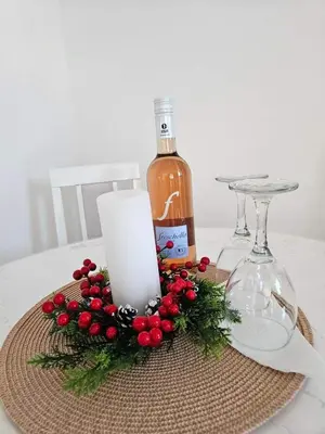 a candle and a bottle of wine on a table at Apartman Gaga in Batajnica