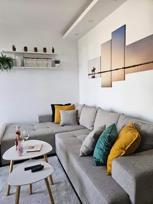 a living room with a gray couch and a table at Apartman Gaga in Batajnica