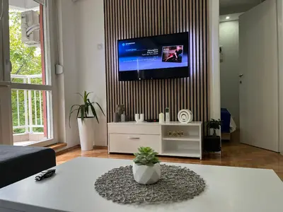 a living room with a tv on a wall at Nele in Bežanija