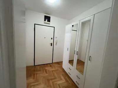 a hallway with a mirror and a white door at Nele in Bežanija