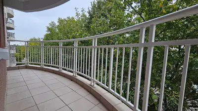 a white railing on a balcony with trees at Nele in Bežanija