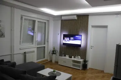 a living room with a couch and a tv on a wall at Nele in Bežanija