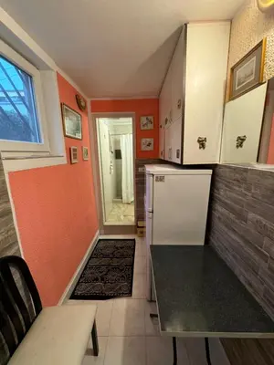 a kitchen with orange walls and a white refrigerator at Jakovljević Apartment in Belgrade