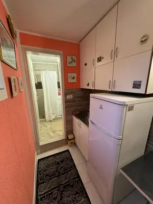 a small kitchen with a white refrigerator and a window at Jakovljević Apartment in Belgrade