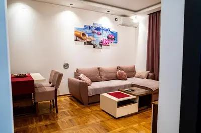 a living room with a couch and a table at Apartman ISKRA - Velvet in Arandjelovac