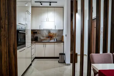 a kitchen with white cabinets and a sink at Apartman ISKRA - Velvet in Arandjelovac