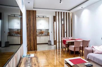 a living room with a table and a couch at Apartman ISKRA - Velvet in Arandjelovac