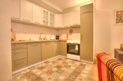 a kitchen with white cabinets and a tile floor at Peaceful Downtown Home in Vračar (historical)
