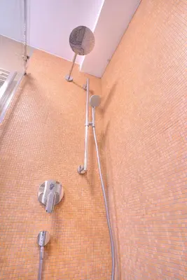 a bathroom with a shower and a fan on the floor at Peaceful Downtown Home in Vračar (historical)
