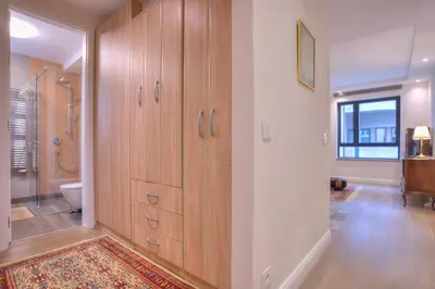 a bathroom with wooden cabinets and a toilet in it at Peaceful Downtown Home in Vračar (historical)