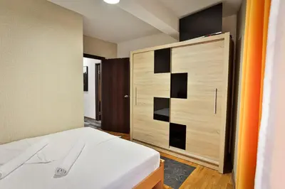 a bedroom with a bed and a wooden cabinet at Malisic apartmani Vračar in Vračar (historical)