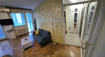 a living room with a blue couch and a door at Blok 1 in Belgrade