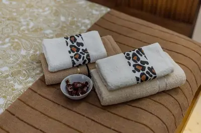 three towels and a bowl of fruit on a table at Megi Zemun Apartment in Zemun