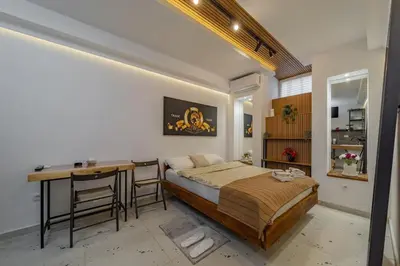 a bedroom with a bed and a desk and a table at Keti Zemun Spa Apartment in Zemun