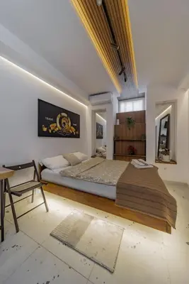 a bedroom with a large bed and a chair at Keti Zemun Spa Apartment in Zemun