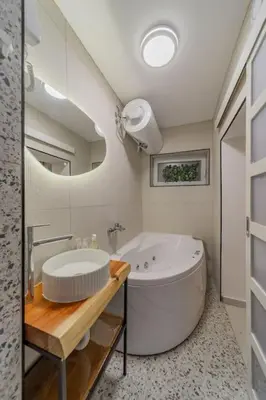 a bathroom with a large tub and a sink at Keti Zemun Spa Apartment in Zemun