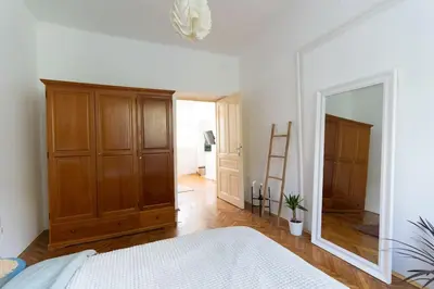 a bedroom with a large wooden cabinet and a mirror at Completely new, Bonbona Apartment Belgrade in Belgrade