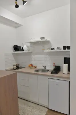 a white kitchen with a sink and a counter at Andjela Apartments in Inđija