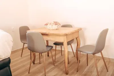 a dining room table with four chairs and a bowl on it at Ranč Elena in Ruma