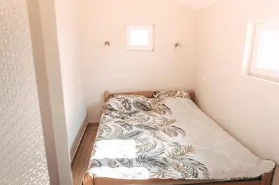 a small bedroom with a bed in the corner at Ranč Elena in Ruma