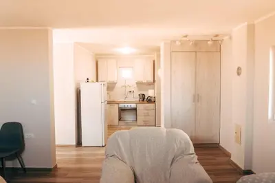 a kitchen with a white refrigerator freezer next to a room at Ranč Elena in Ruma