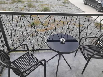 a table and two chairs on a balcony at Apartman Bika in Surčin