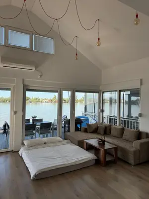a bedroom with a bed and a couch and a table at Beautiful houseboat on the Sava river in Belgrade
