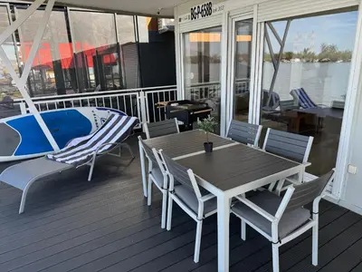 a wooden deck with a table and chairs on a boat at Beautiful houseboat on the Sava river in Belgrade