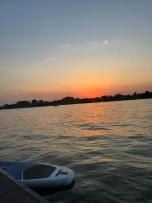 a boat sitting in the water at sunset at Beautiful houseboat on the Sava river in Belgrade