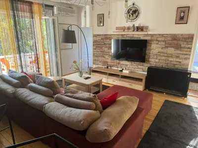 a living room with a large couch and a television at Zvezda in Karaburma