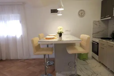 a kitchen with a table and chairs in a kitchen at Airport Studio Stefan in Belgrade