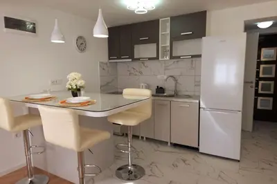 a kitchen with a counter and a white refrigerator at Airport Studio Stefan in Belgrade